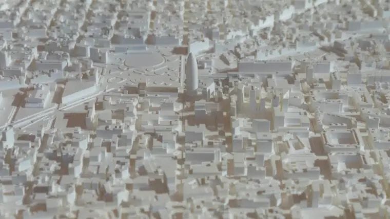 Maqueta urbana en blanc i beige amb una trama de carrers, edificis i un gran avinguda central