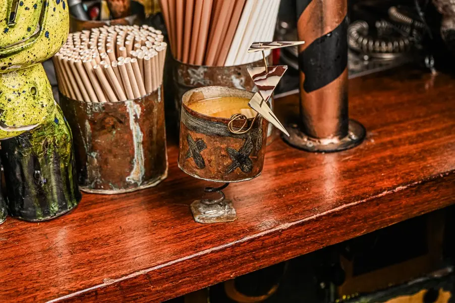 EL GUARDIÀ: en nombre de la bestia del barrio de Les Corts:
• Ron especiado propio y artesanal.
• Licor amaro.
• Zumo de limón.
• Plátano.
• Galleta Biscoff de caramelo.
• Zumo de mango.
• Chocolate artístico.